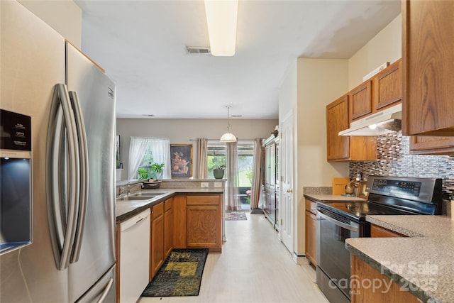 11440 Lamoille Ln, Charlotte, NC 28278 - kitchen with stainless steel appliances, under cabinet range hood, brown cabinetry, and light floors