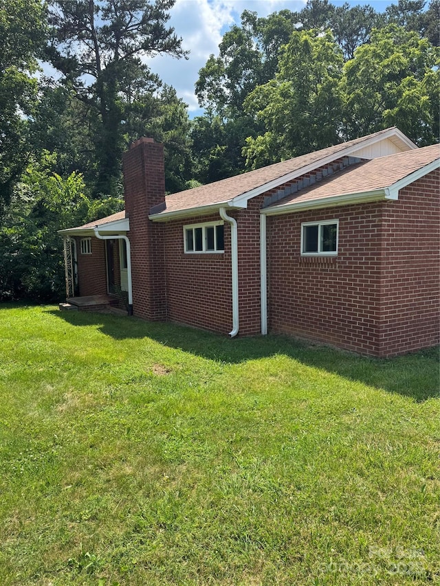 1239 8th St NE, Hickory, NC 28601 - back of property featuring a chimney, a yard, and brick siding