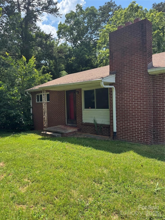 1239 8th St NE, Hickory, NC 28601 - view of front of property with a front lawn, a chimney, and brick siding
