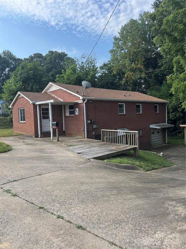 1239 8th St NE, Hickory, NC 28601 - back of house with brick siding, a deck, driveway, and a garage