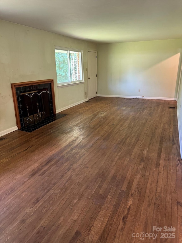 1239 8th St NE, Hickory, NC 28601 - unfurnished living room with dark wood-style floors and a tile fireplace