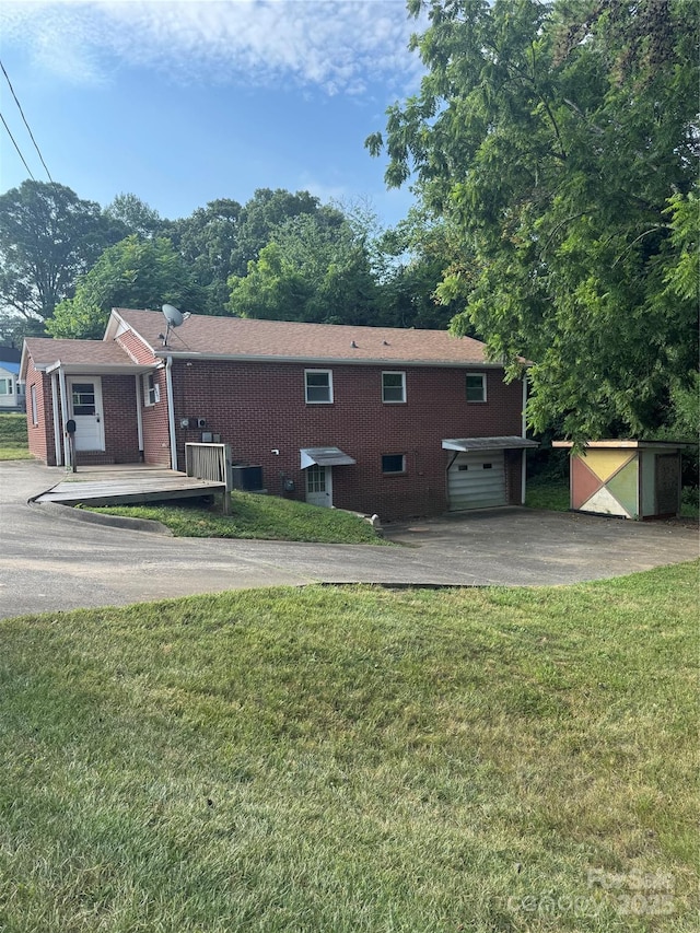 1239 8th St NE, Hickory, NC 28601 - back of property featuring driveway, a storage shed, a lawn, a garage, and brick siding