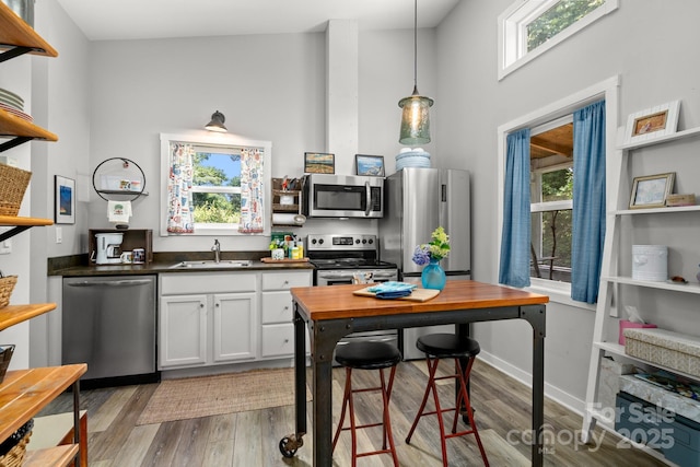 211 Summer St, Swannanoa, NC 28778 - kitchen featuring stainless steel appliances, open shelves, dark countertops, a high ceiling, and light wood finished floors