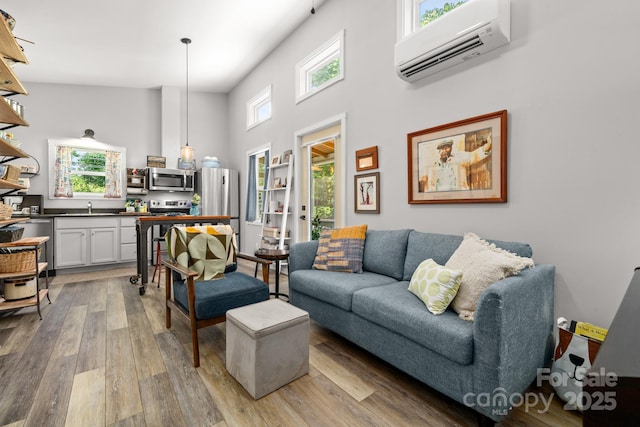 211 Summer St, Swannanoa, NC 28778 - living area featuring a wall mounted air conditioner, light wood-style flooring, and a high ceiling