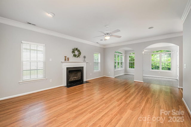 7731 Sedgebrook Dr E, Stanley, NC 28164 - unfurnished living room with healthy amount of natural light, a ceiling fan, a fireplace with flush hearth, ornamental molding, and light wood-style floors