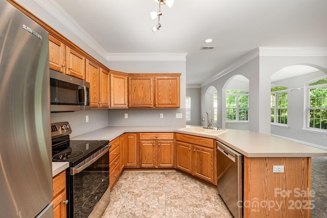 7731 Sedgebrook Dr E, Stanley, NC 28164 - kitchen with appliances with stainless steel finishes, a peninsula, ornamental molding, light countertops, and arched walkways