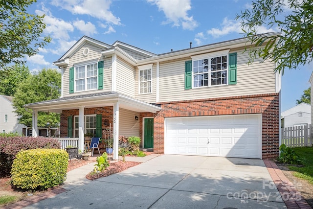4732 Meadowfield Rd Unit L35, Charlotte, NC 28215 - traditional-style home with brick siding, concrete driveway, an attached garage, and covered porch