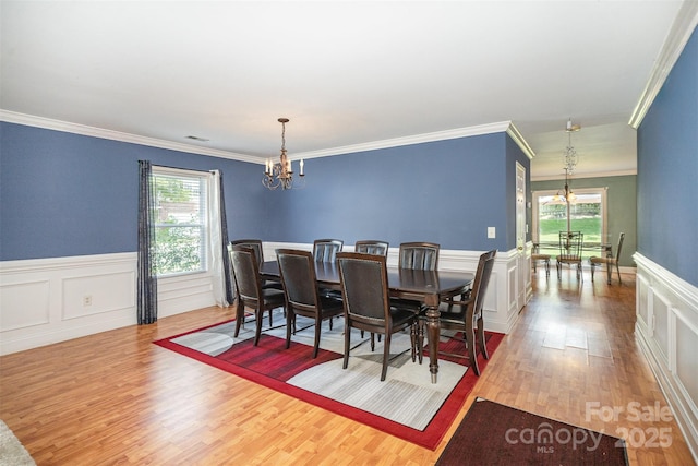 4732 Meadowfield Rd Unit L35, Charlotte, NC 28215 - dining space with a chandelier, wood finished floors, ornamental molding, a wainscoted wall, and a decorative wall