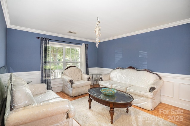 4732 Meadowfield Rd Unit L35, Charlotte, NC 28215 - living area with a wainscoted wall, wood finished floors, crown molding, and a decorative wall
