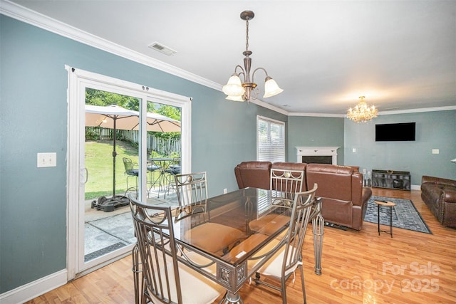 4732 Meadowfield Rd Unit L35, Charlotte, NC 28215 - dining room with a chandelier, crown molding, light wood finished floors, and a fireplace