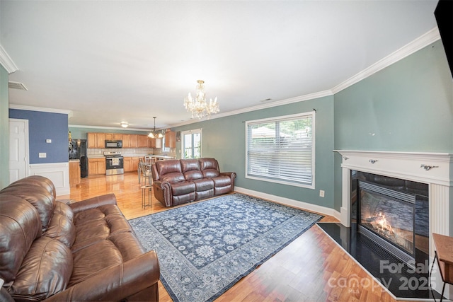 4732 Meadowfield Rd Unit L35, Charlotte, NC 28215 - living area with a chandelier, ornamental molding, a fireplace with flush hearth, and light wood-type flooring