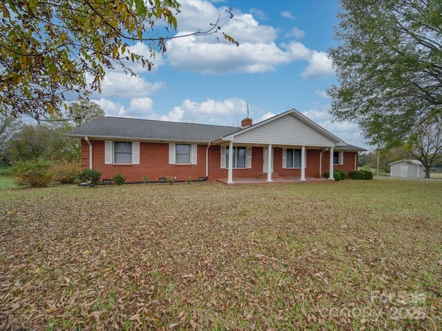 3113 Old Pageland Marshville Rd, Wingate, NC 28174 - ranch-style house featuring brick siding, a front lawn, covered porch, a chimney, and a storage shed