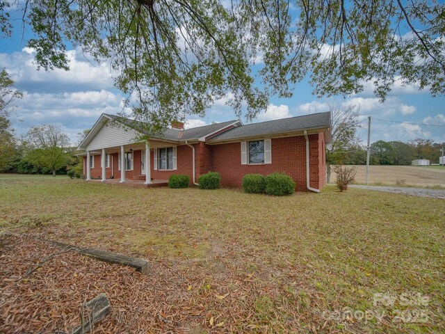 3113 Old Pageland Marshville Rd, Wingate, NC 28174 - ranch-style house with brick siding, a front yard, a porch, and a chimney