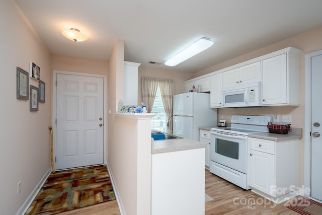 407 Hertling Dr NW, Concord, NC 28027 - kitchen featuring white appliances, light wood-style flooring, white cabinets, light countertops, and a peninsula