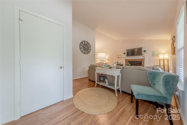 6418 Tivoli Ct, Charlotte, NC 28211 - living room featuring light wood-type flooring, a fireplace, and vaulted ceiling