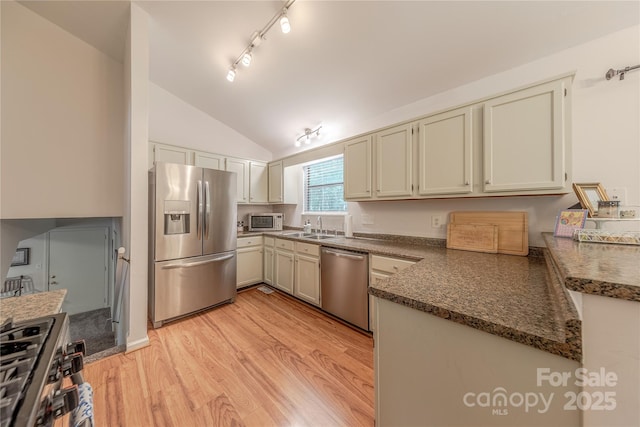 6418 Tivoli Ct, Charlotte, NC 28211 - kitchen featuring stainless steel appliances, vaulted ceiling, light wood-type flooring, track lighting, and dark stone counters
