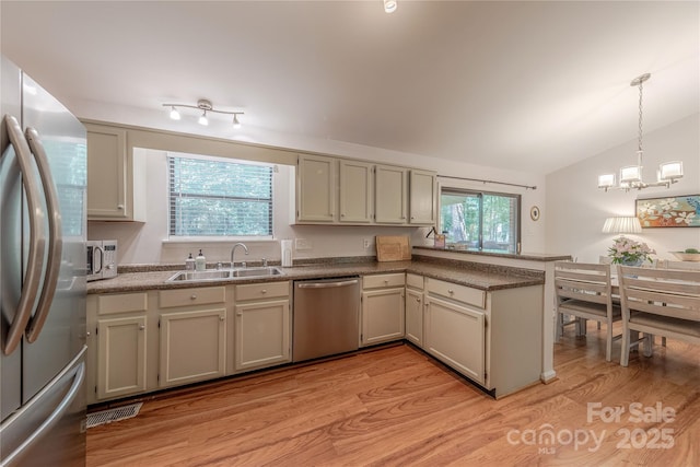 6418 Tivoli Ct, Charlotte, NC 28211 - kitchen with stainless steel appliances, a peninsula, light wood-type flooring, vaulted ceiling, and plenty of natural light