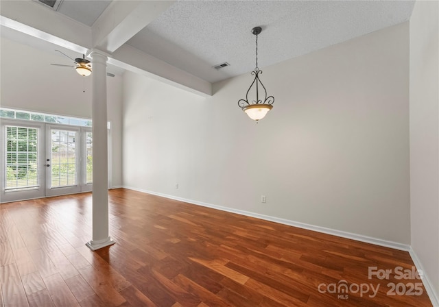 1326 Anthem Ct, Charlotte, NC 28205 - empty room with ornate columns, ceiling fan, dark wood-type flooring, and a textured ceiling