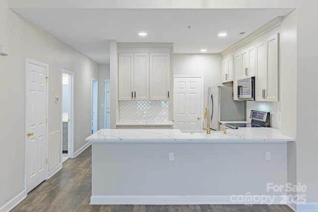 795 Peninsula Dr, Davidson, NC 28036 - kitchen with stainless steel appliances, decorative backsplash, a peninsula, light stone countertops, and recessed lighting