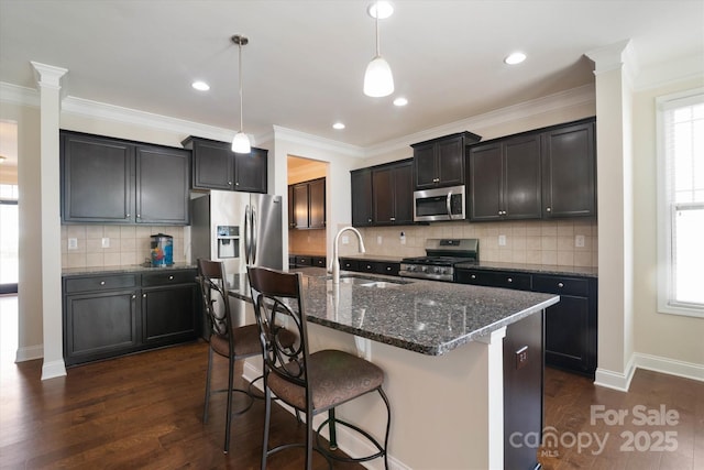 12704 Franklin Square Rd, Charlotte, NC 28213 - kitchen with appliances with stainless steel finishes, a kitchen bar, dark wood-type flooring, dark stone counters, and backsplash