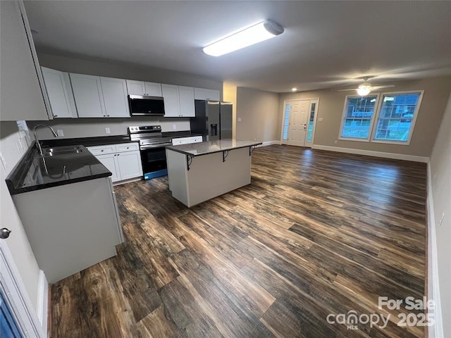 507 Putter Pl, Chester, SC 29706 - kitchen with appliances with stainless steel finishes, dark wood-style flooring, a kitchen island, open floor plan, and dark countertops
