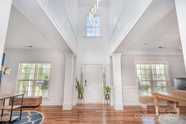 2380 Fairport Dr SE, Concord, NC 28025 - foyer entrance with decorative columns, wood finished floors, plenty of natural light, a decorative wall, and wainscoting