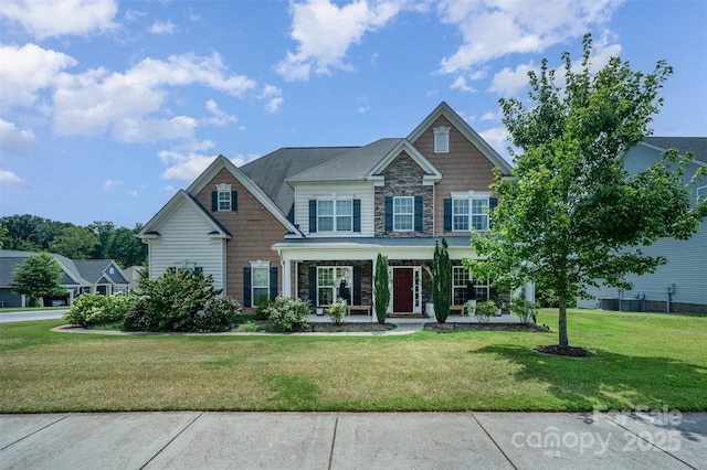 2380 Fairport Dr SE, Concord, NC 28025 - craftsman house featuring stone siding, a front yard, and a porch