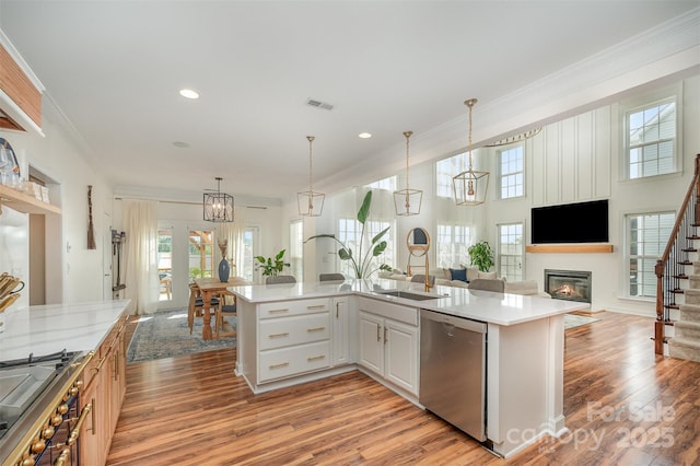 2380 Fairport Dr SE, Concord, NC 28025 - kitchen featuring appliances with stainless steel finishes, open floor plan, light countertops, ornamental molding, and a glass covered fireplace