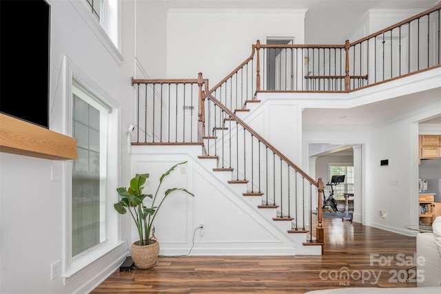 2380 Fairport Dr SE, Concord, NC 28025 - staircase with a towering ceiling, wood finished floors, and ornamental molding