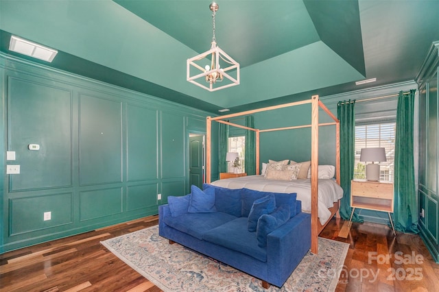 2380 Fairport Dr SE, Concord, NC 28025 - bedroom featuring a decorative wall, a chandelier, and wood finished floors