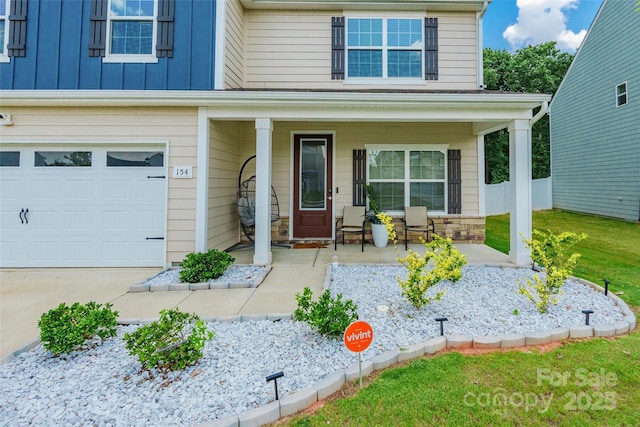 154 Tanner Loop, Troutman, NC 28166 - view of front of home featuring a porch, an attached garage, and stone siding