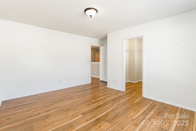 2357 Riding Trail Rd, Gastonia, NC 28054 - unfurnished bedroom featuring a closet, light wood-style flooring, a spacious closet, and ornamental molding