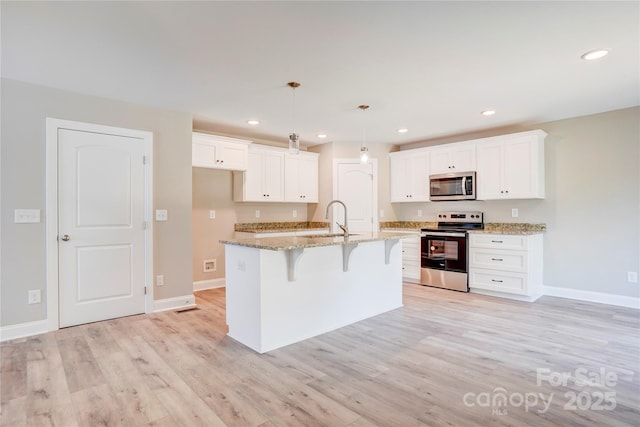 206 N Kayla Dr, Salisbury, NC 28146 - kitchen with stainless steel appliances, white cabinets, light wood-style floors, a breakfast bar, and recessed lighting