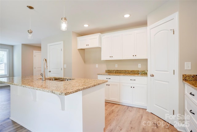 206 N Kayla Dr, Salisbury, NC 28146 - kitchen featuring light wood finished floors, white cabinets, decorative light fixtures, light stone counters, and recessed lighting