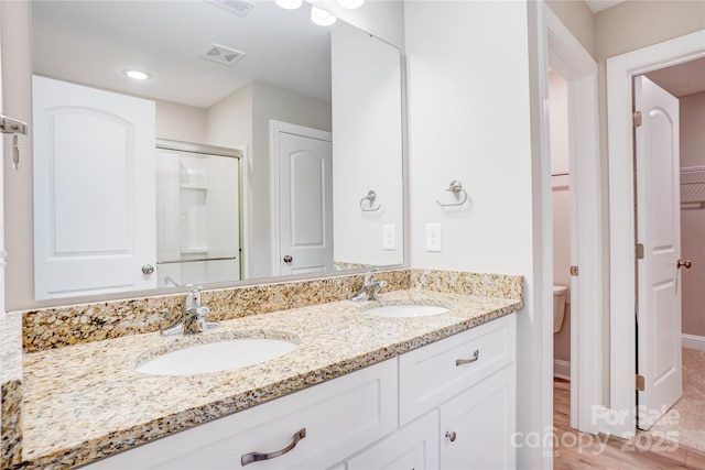 206 N Kayla Dr, Salisbury, NC 28146 - full bathroom with double vanity, wood finished floors, a shower with door, and a spacious closet