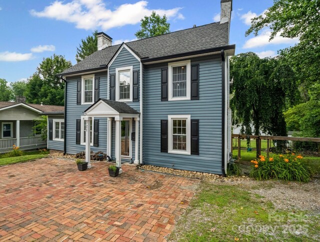 321 Ehringhaus St, Hendersonville, NC 28739 - colonial house with a chimney, a patio area, and roof with shingles