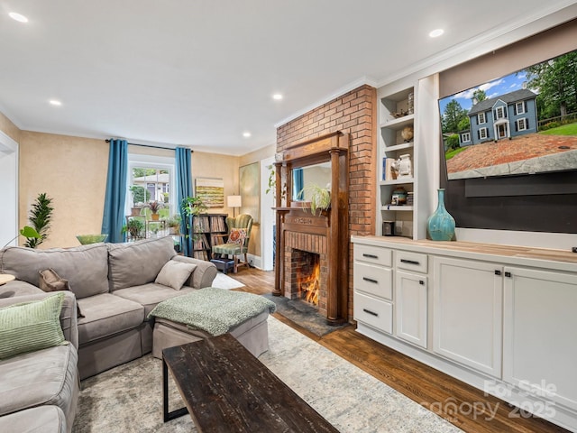 321 Ehringhaus St, Hendersonville, NC 28739 - living room featuring a brick fireplace, wood finished floors, ornamental molding, recessed lighting, and built in shelves