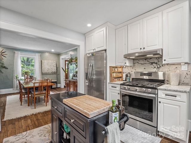 321 Ehringhaus St, Hendersonville, NC 28739 - kitchen featuring appliances with stainless steel finishes, under cabinet range hood, white cabinets, dark wood finished floors, and tasteful backsplash