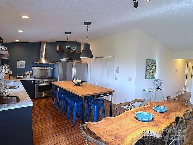 617 Norton Fork Rd, Hot Springs, NC 28743 - kitchen with wall chimney exhaust hood, appliances with stainless steel finishes, dark wood finished floors, butcher block counters, and recessed lighting