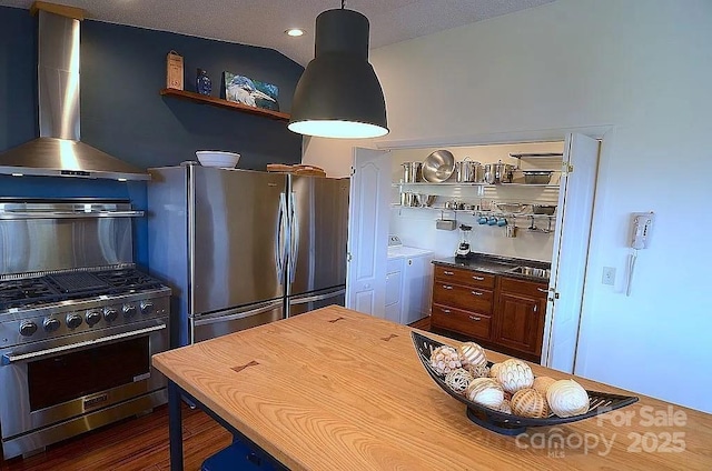 617 Norton Fork Rd, Hot Springs, NC 28743 - kitchen with appliances with stainless steel finishes, wall chimney range hood, washing machine and dryer, open shelves, and dark wood-style flooring