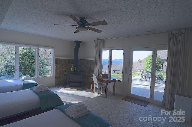 617 Norton Fork Rd, Hot Springs, NC 28743 - living area with a wood stove, carpet flooring, a textured ceiling, ceiling fan, and french doors