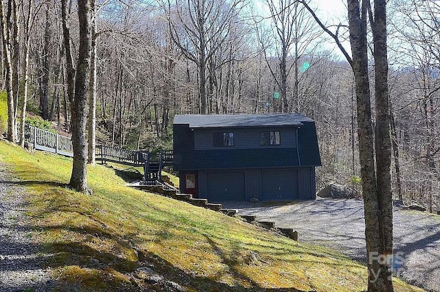 617 Norton Fork Rd, Hot Springs, NC 28743 - view of front facade featuring a garage, a forest view, gravel driveway, and a front yard