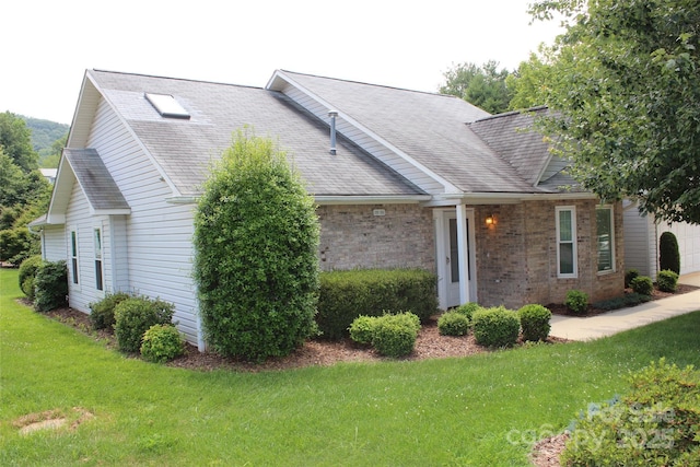 4 Gatehouse Ct, Asheville, NC 28803 - view of front of house featuring a front yard, roof with shingles, brick siding, and an attached garage