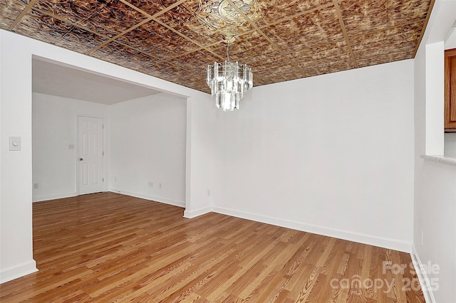 8062 Knights Bridge Rd, Charlotte, NC 28210 - spare room featuring an ornate ceiling, a chandelier, and light wood-style floors