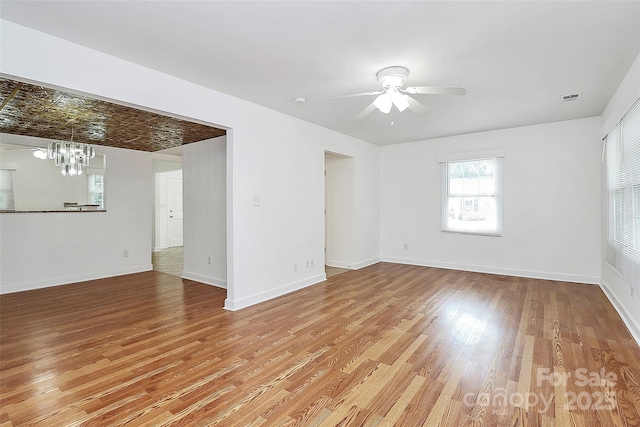 8062 Knights Bridge Rd, Charlotte, NC 28210 - empty room with a chandelier, ceiling fan, and light wood finished floors