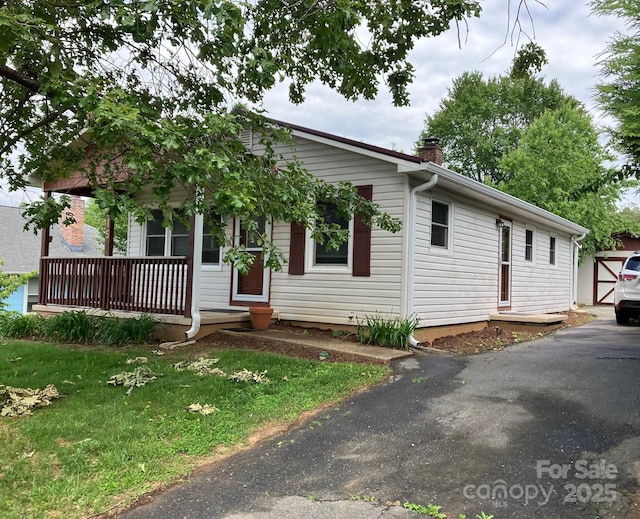 615 Marietta St, Asheville, NC 28803 - ranch-style home featuring a porch, a chimney, and a front lawn