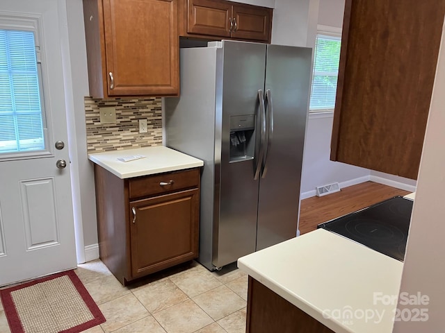 615 Marietta St, Asheville, NC 28803 - kitchen featuring stainless steel fridge with ice dispenser, range, tasteful backsplash, and light countertops