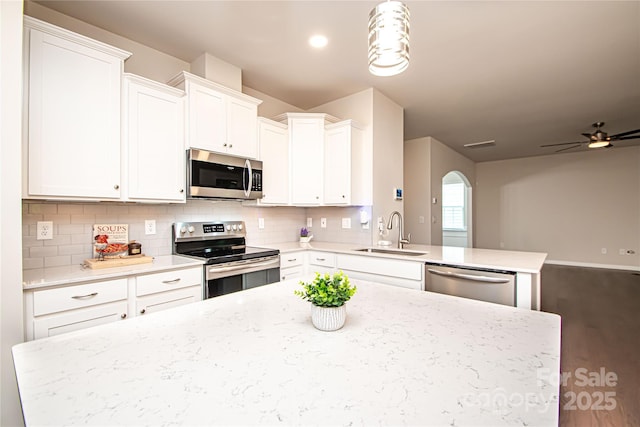 17718 Terryglass Ln, Charlotte, NC 28278 - kitchen featuring stainless steel appliances, tasteful backsplash, white cabinets, arched walkways, and open floor plan