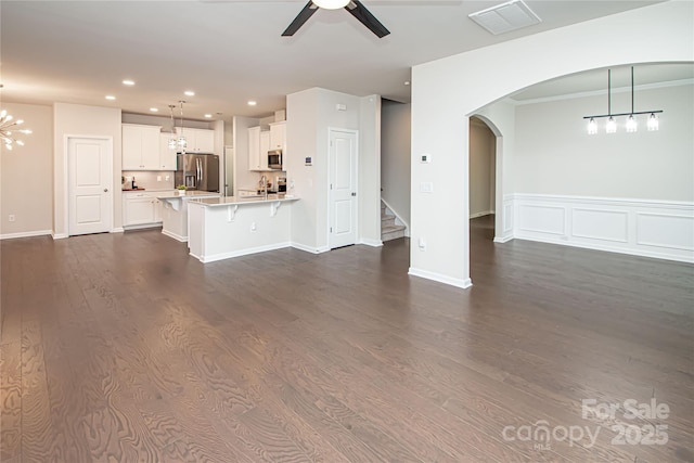17718 Terryglass Ln, Charlotte, NC 28278 - unfurnished living room featuring a ceiling fan, recessed lighting, arched walkways, dark wood finished floors, and stairway