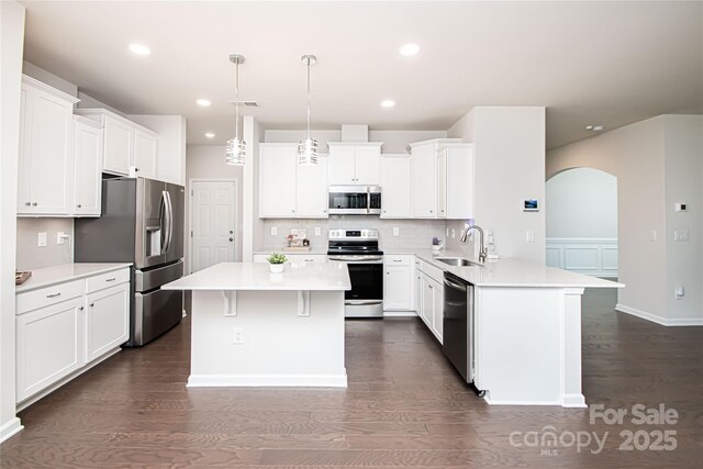 17718 Terryglass Ln, Charlotte, NC 28278 - kitchen featuring appliances with stainless steel finishes, a breakfast bar, a peninsula, dark wood-style flooring, and recessed lighting